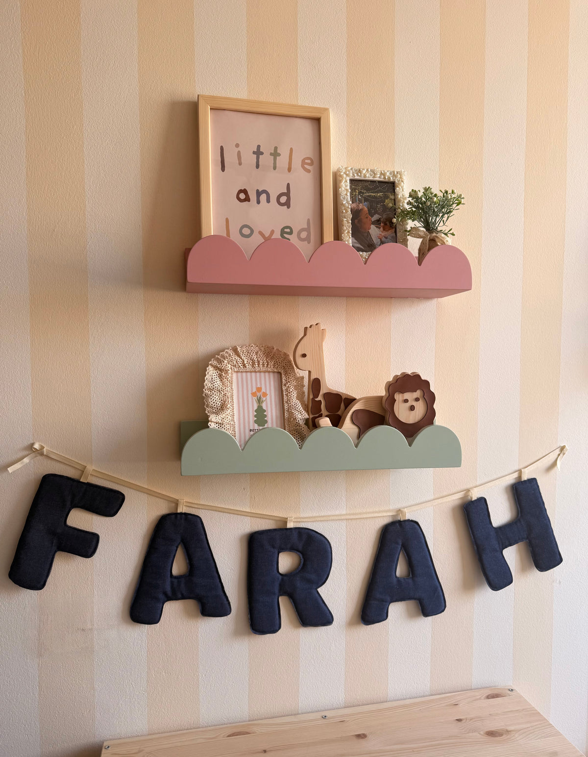 Set of two colorful cloud-shaped wall shelves styled with framed photos and nursery decor in a kids’ bedroom.